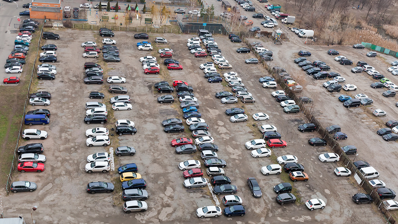 Parkplatz ohne Asphaltbelag mit parkenden Autos aus der Vogelperspektive